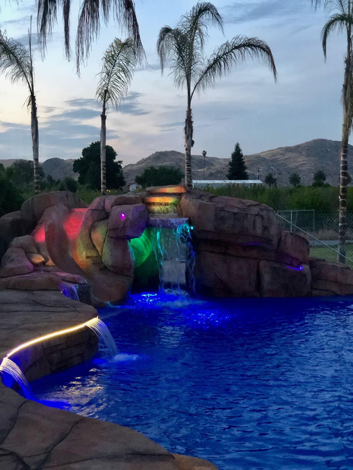 Rock waterfall grotto at twilight with color lighting